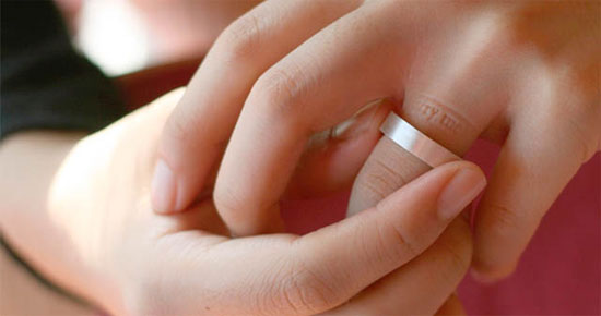 Wedding ring imprints marry me message on finger